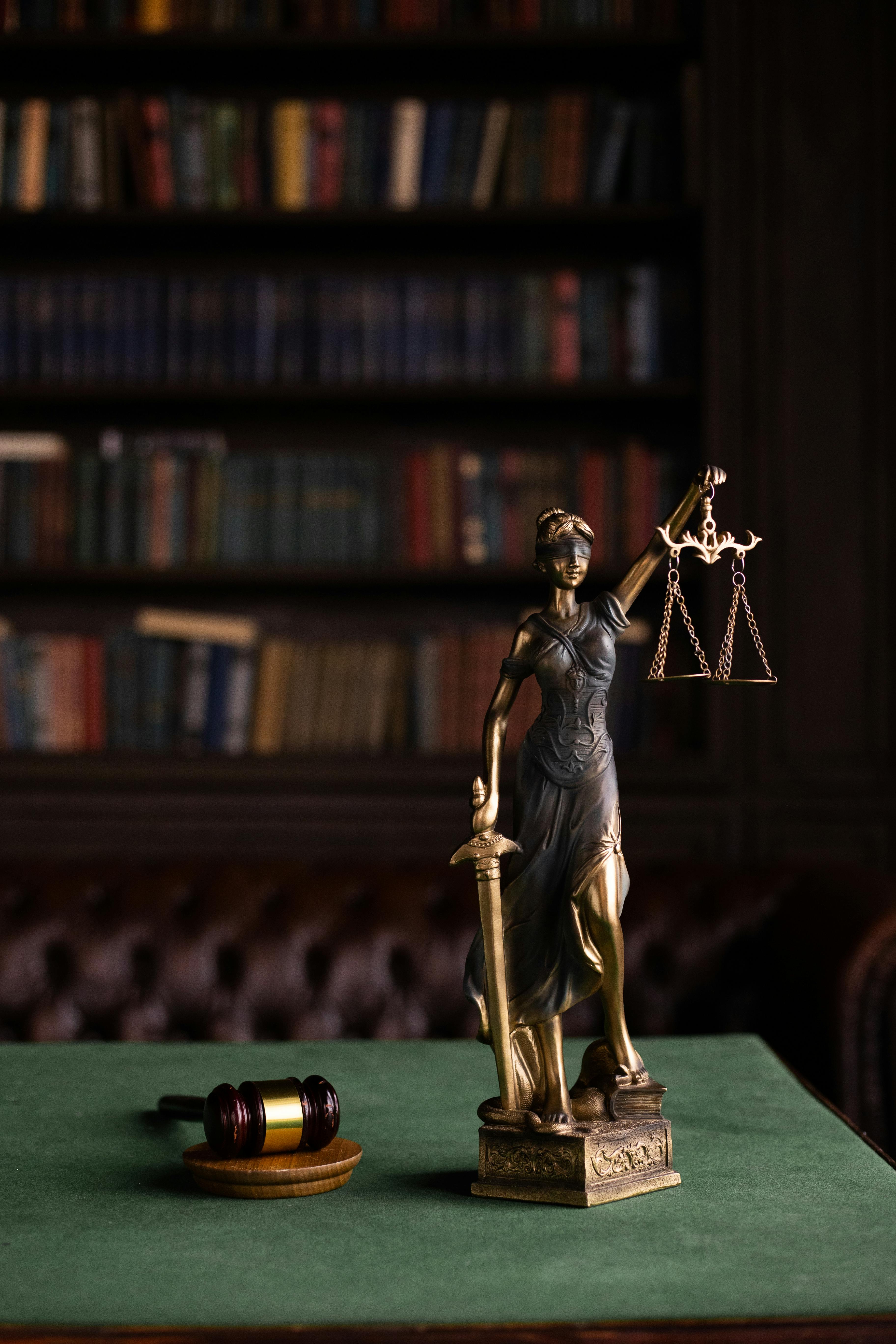 zipwp image 6077123 Lady Justice and gavel on a table in a classic law library setting.
