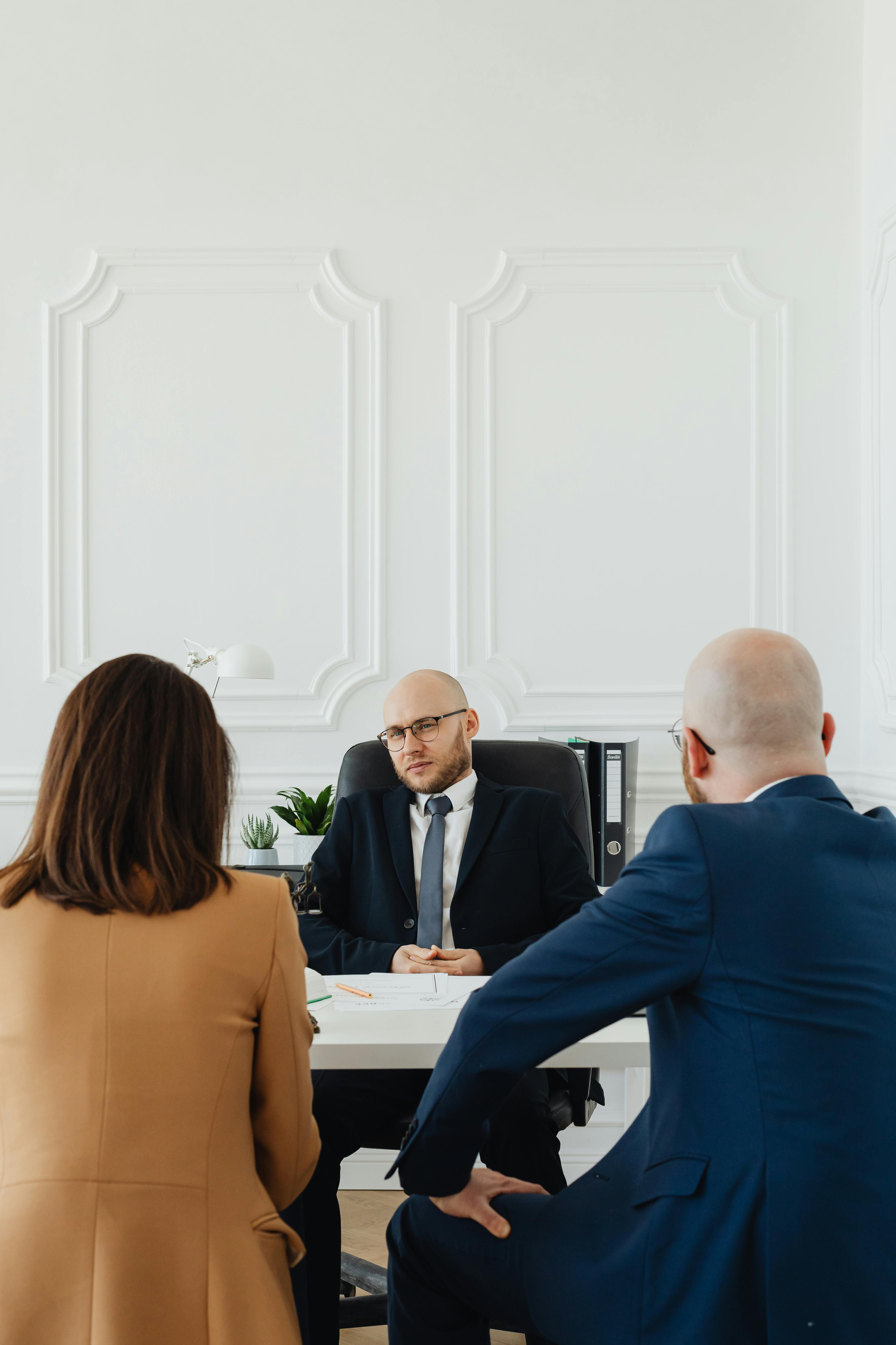 zipwp image 7876290 A lawyer consults a couple on divorce proceedings in an elegant office setting.